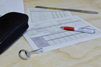 A table with an isolation checklist, a WTS pen, and an electrical cabinet key for electrical work.