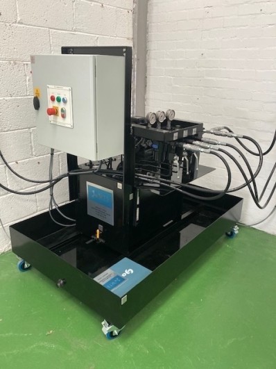 Hydraulic training rig by WTS featuring a machine with an attached hose for educational purposes.
