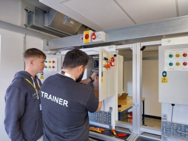 Dominic teaching a learner on the electrical training rig.